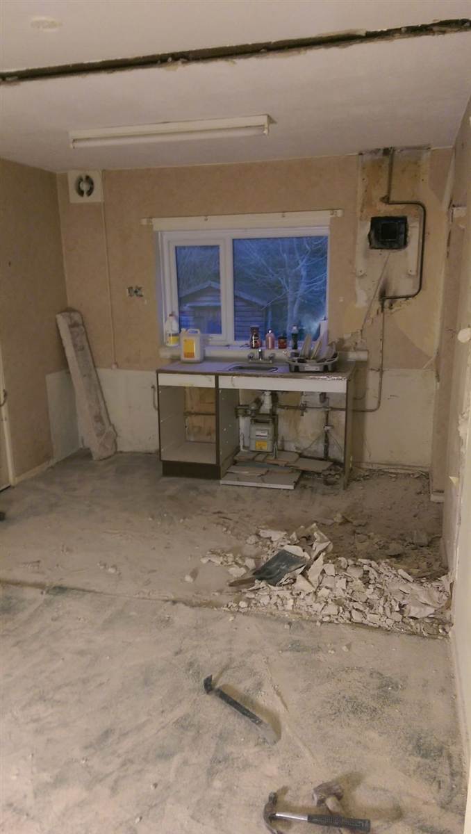 During — room stripped back to bare walls and concrete floor, services exposed, blank canvas